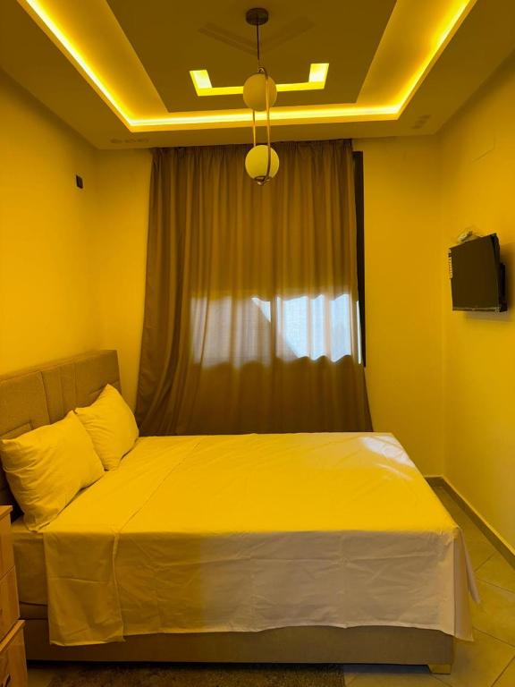 a yellow bedroom with a bed with a window at Dar aya comfort in Oulad Embarek