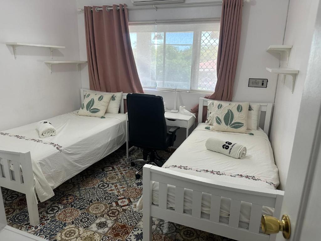 a room with two beds and a desk and a window at Mains Rd 舒适双人间2张床M2 in Brisbane
