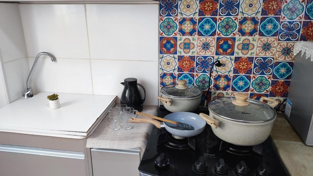 een keuken met twee potten en pannen op een fornuis bij Apartamento Santa Isabel in Cuiabá
