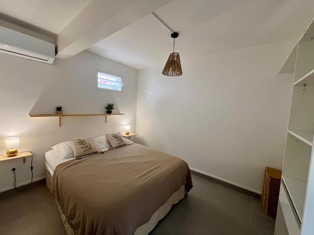a bedroom with a bed in a white room at Casa Caraïbe in Les Trois-Îlets