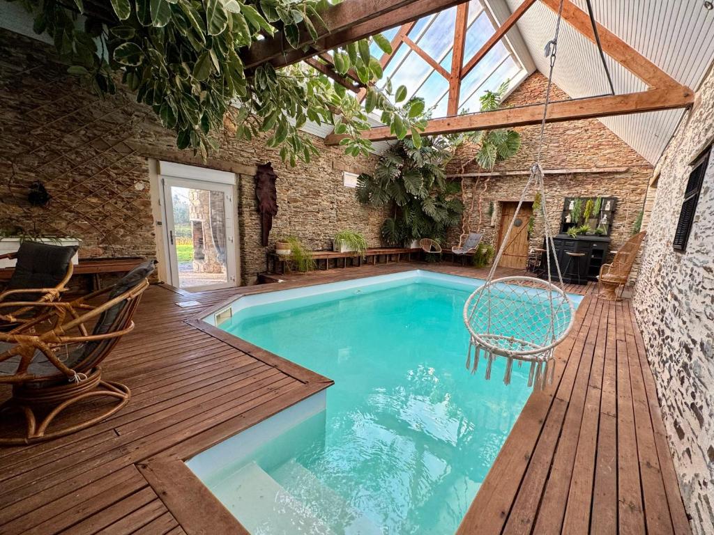 an indoor pool with a swing in a building at Le grand Brandonné in Loiré