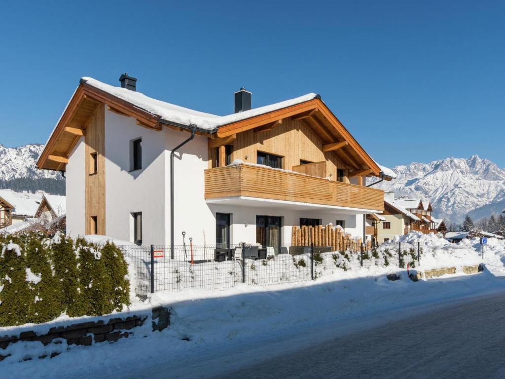 a house in the snow with mountains in the background at Hirnreit in Leogang