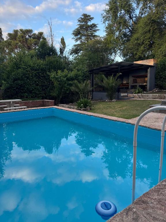 a blue swimming pool with a house in the background at Chalet La Isolina in Villa Giardino