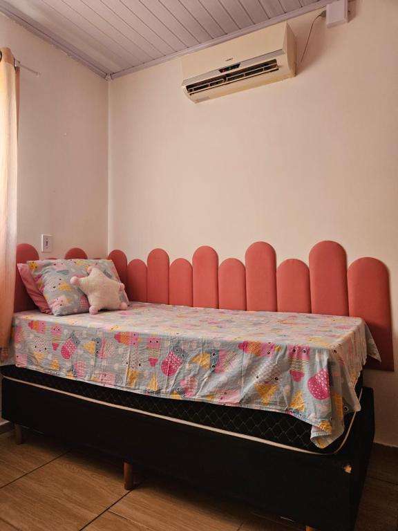 une chambre avec un lit avec une chaise rouge dans l'établissement Casa da Família Flores, à Rosário do Sul