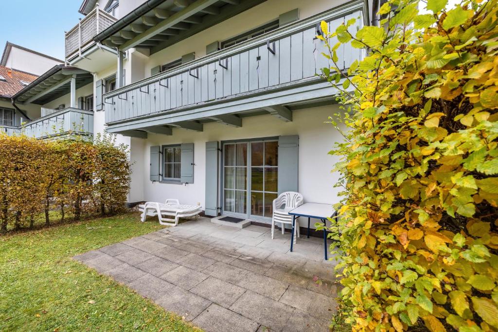 a patio with a table and chairs in front of a house at Fewo Brünnstein - Zimmer 6 in Oberaudorf
