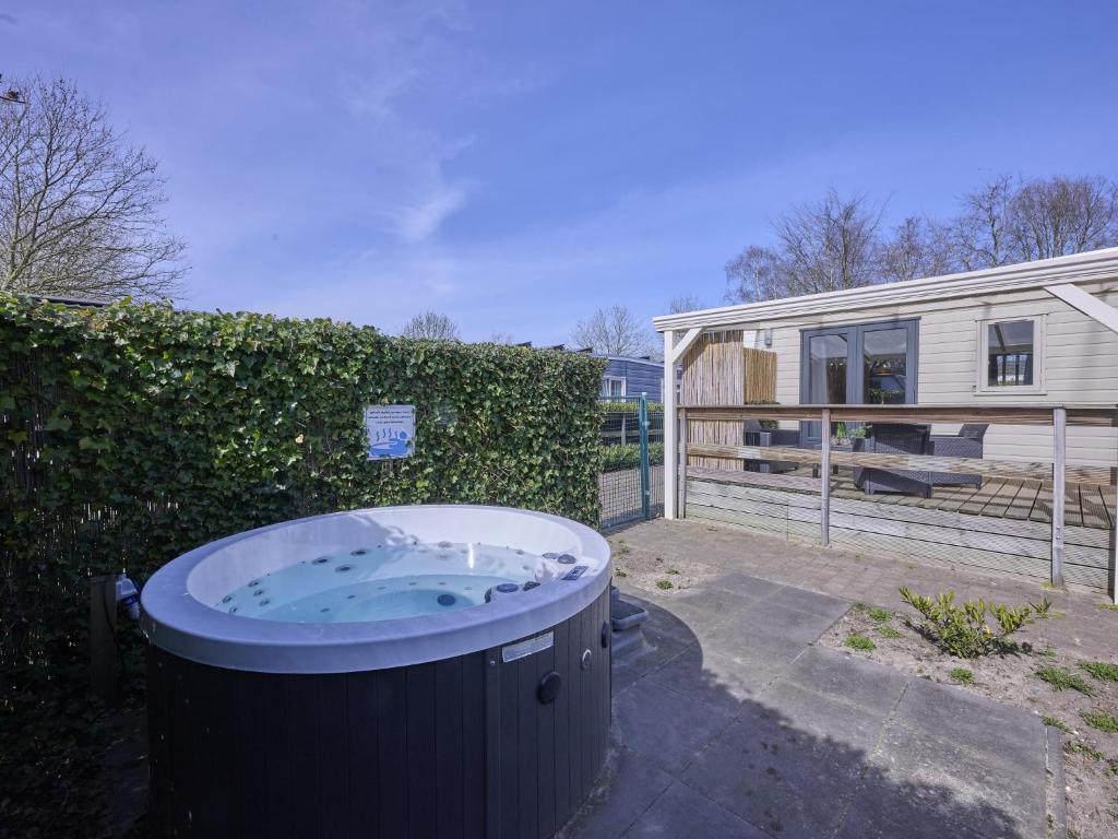 a large hot tub in a yard next to a house at t Kaatsheuveltje 7 in Kaatsheuvel