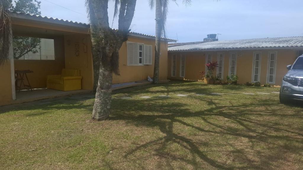 ein Haus mit einem davor geparkten Auto in der Unterkunft Casa Piccolo Paradiso 4 quartos in Balneário Gaivotas