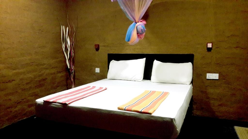Un dormitorio con una cama grande con un globo en la pared. en Golden Nature Cottage, en Udawalawe