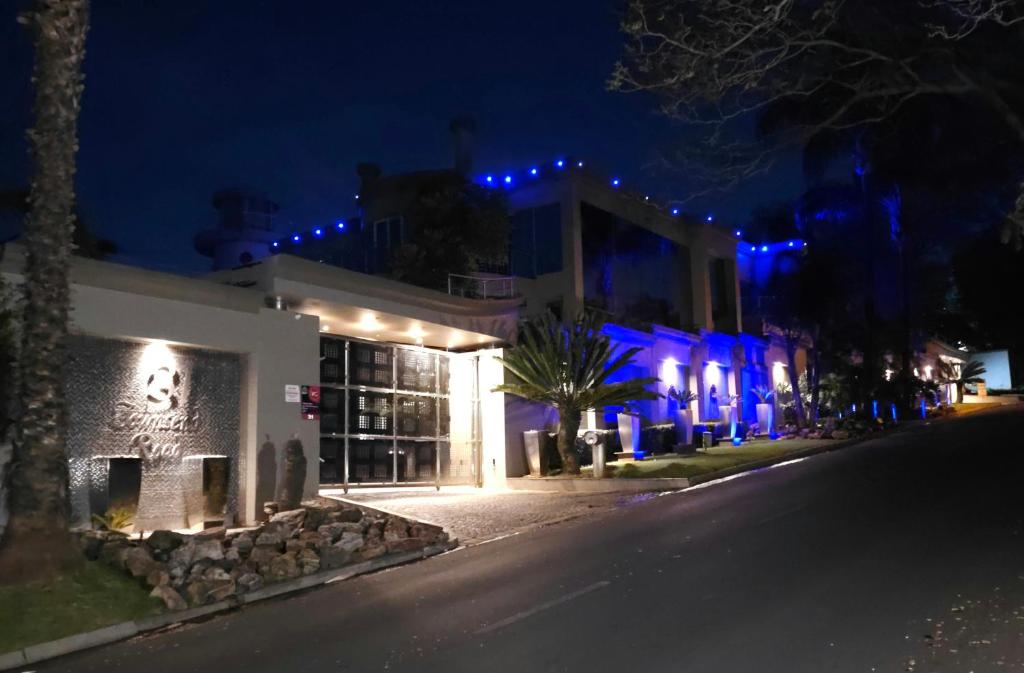 Un edificio con luces azules en una calle por la noche. en Silva Villa, en Bedfordview