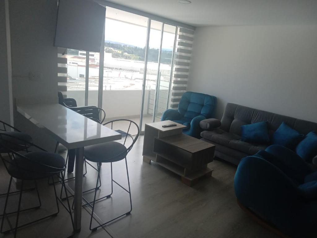 La mejor ubicación y tú mejor opción en Paipa في بايبا: غرفة معيشة مع أريكة وطاولة وكراسي