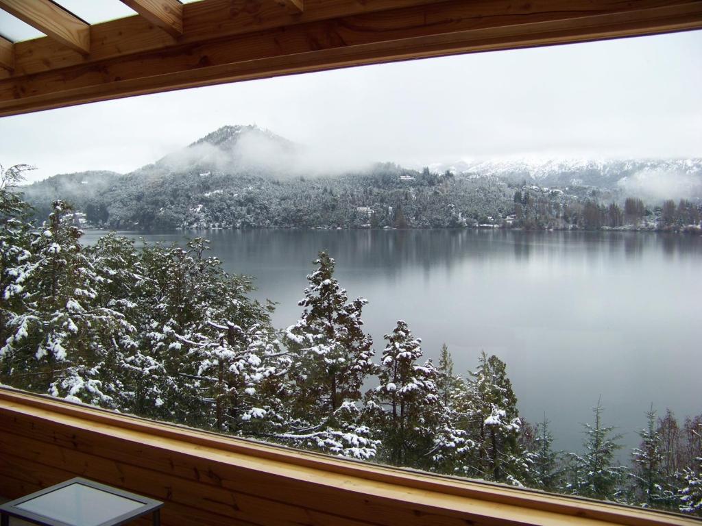 Blick aus einem Fenster auf einen schneebedeckten Berg in der Unterkunft Peninsula Petit in San Carlos de Bariloche