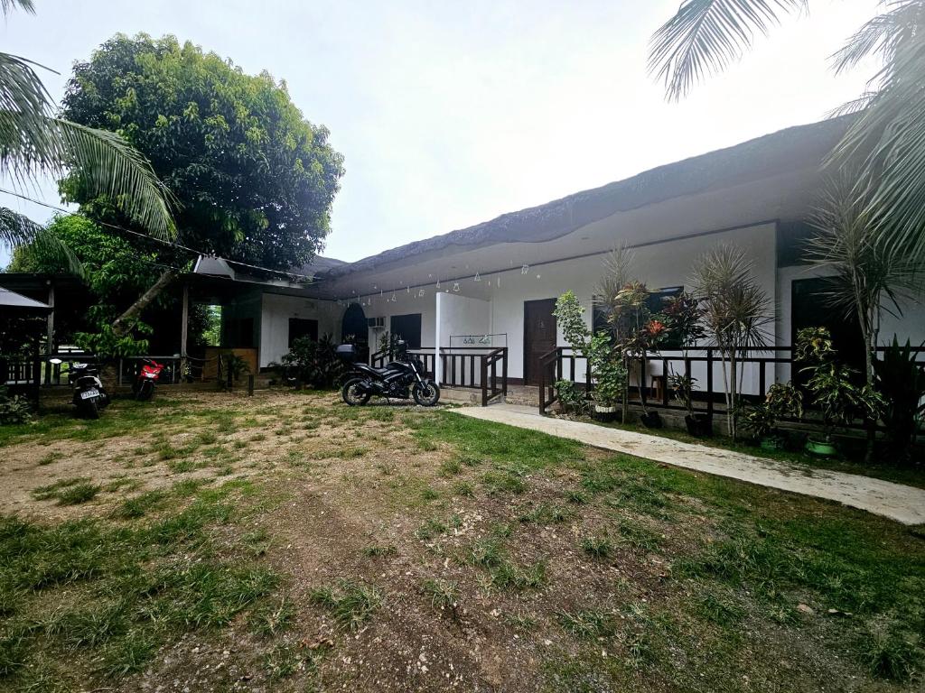 een huis met een motor ervoor geparkeerd bij Rooms in Apo-estin in Cangatuyom