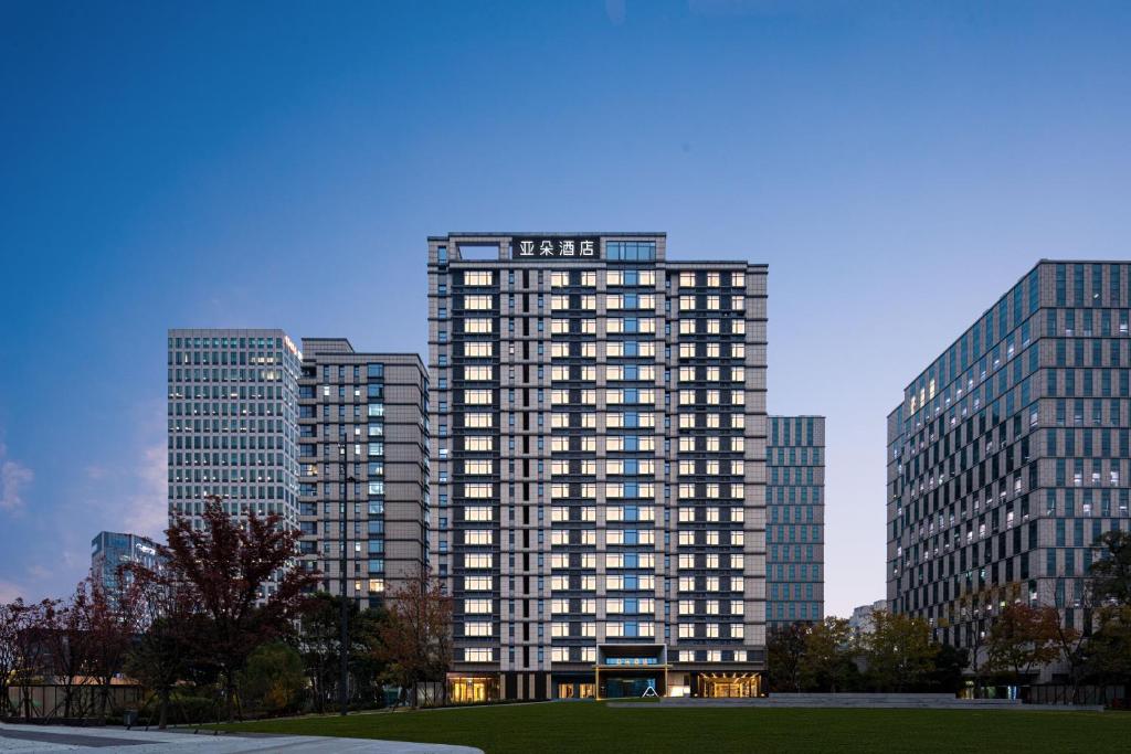 a tall building in front of some tall buildings at Atour Hotel Shanghai Wujiaochang Wanda Plaza in Shanghai