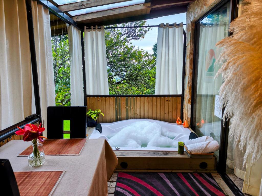 a room with a tub in a room with a window at CABAÑAS MONTEVERDE - Guarne ANT in Guarne