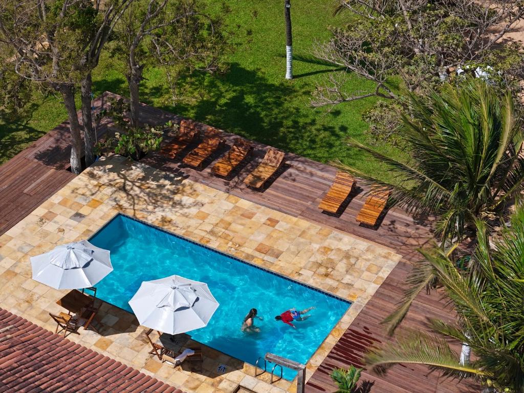 an overhead view of a swimming pool with umbrellas at Chalé Heloísa Jericoacoara in Jericoacoara