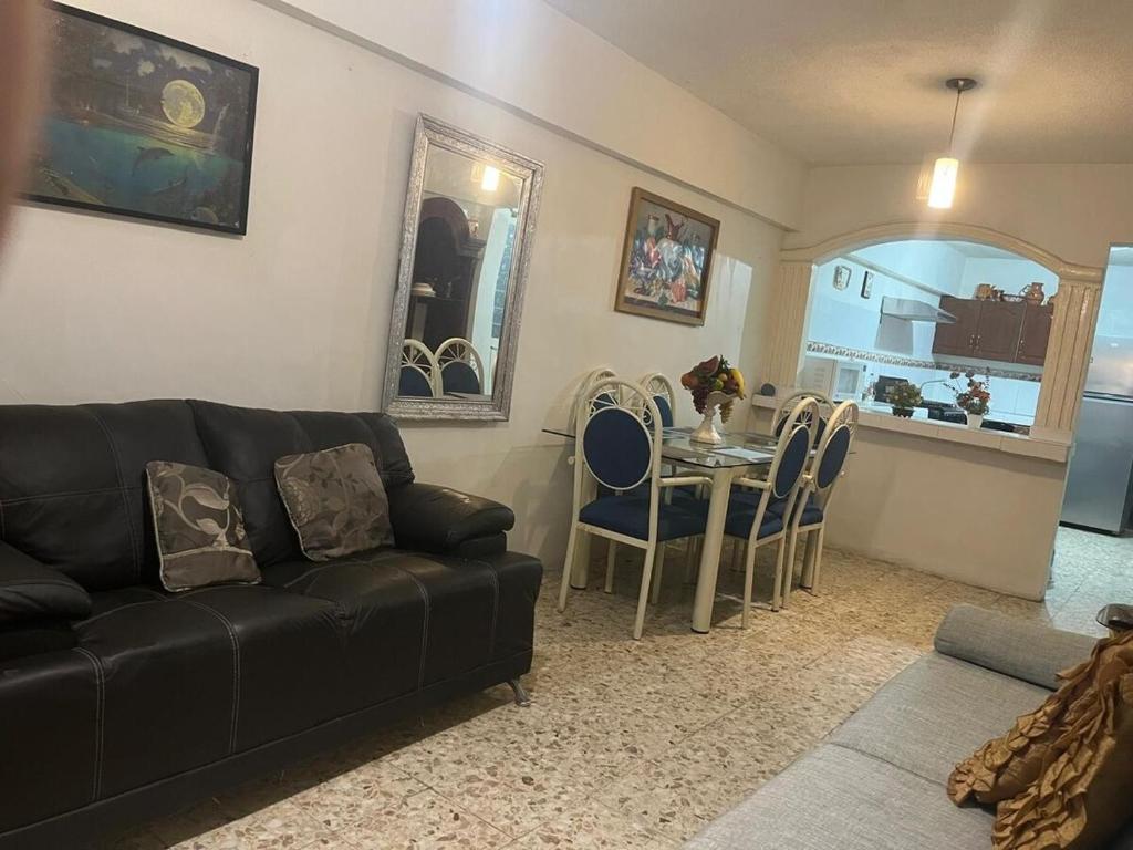 a living room with a black couch and a table at Cozy and family - house Fundidora & Cintermex in Monterrey