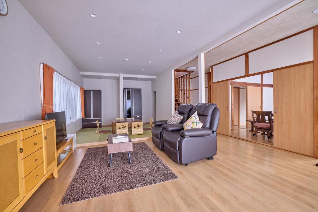 a living room with a couch and a television at APROStay富士河口湖小立17 in Fujikawaguchiko