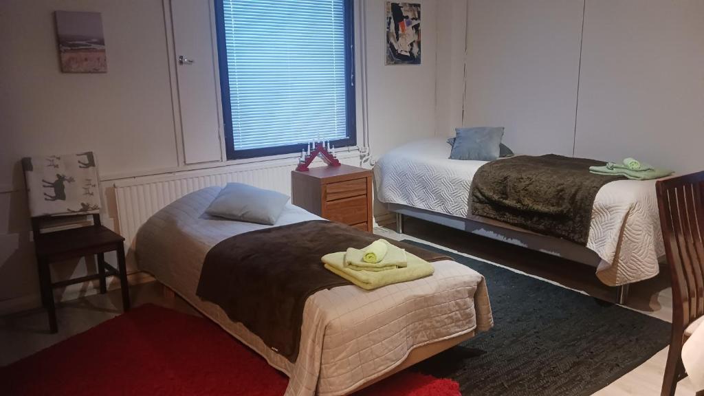 a bedroom with two beds and a table with towels at Cozy economy room for 2 persons at the shopping area in Rovaniemi