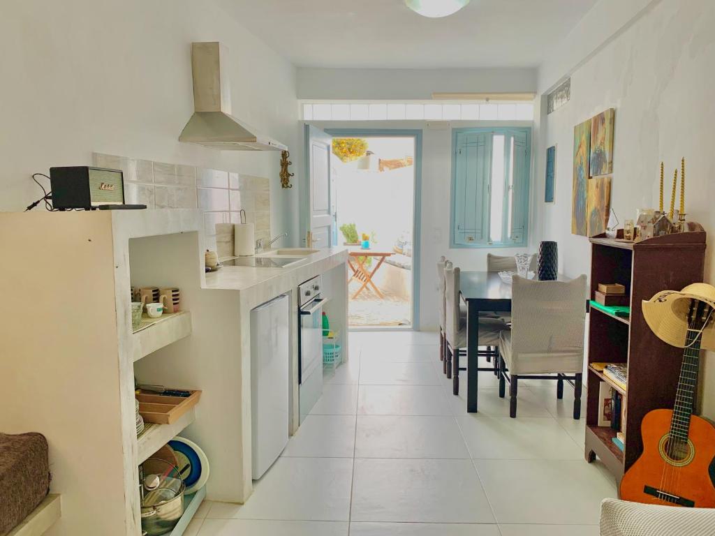 a kitchen and dining room with a table and a guitar at Lupi's Cave House in Fira