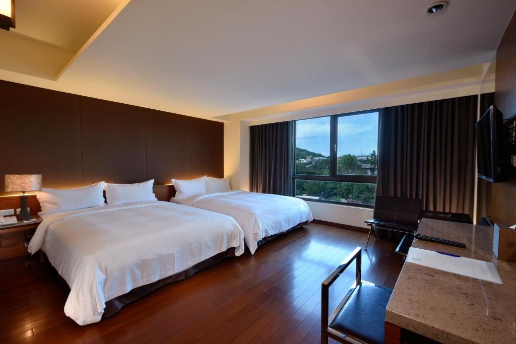 Habitación de hotel con 2 camas y ventana grande. en Fu Lyu Inn, en Hualien City