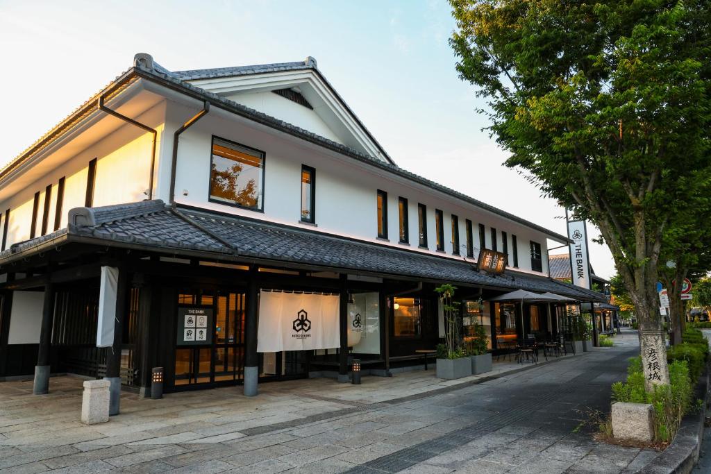 a building on a street next to a tree at HATAGO HIKONE - Main building in Hikone
