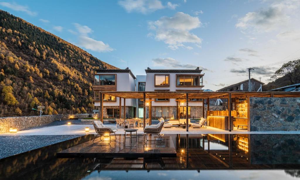 a house with a view of a mountain at Siguniang Mountain Waiting for the Wind Snow Mountain Guesthouse in Mount Siguniang