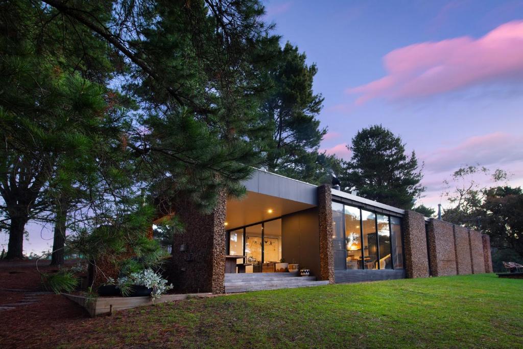a house with glass windows and a lawn at Gabion Hill in Glenlyon