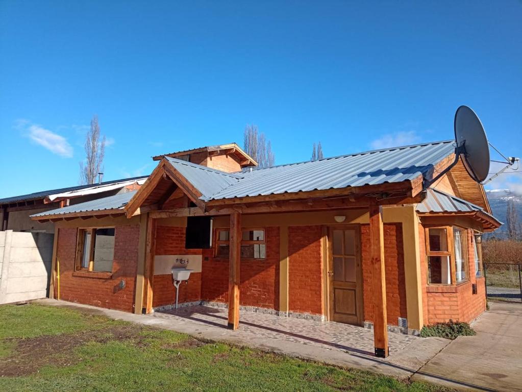 a house with a metal roof on top of it at Anlupa Casa in El Bolsón