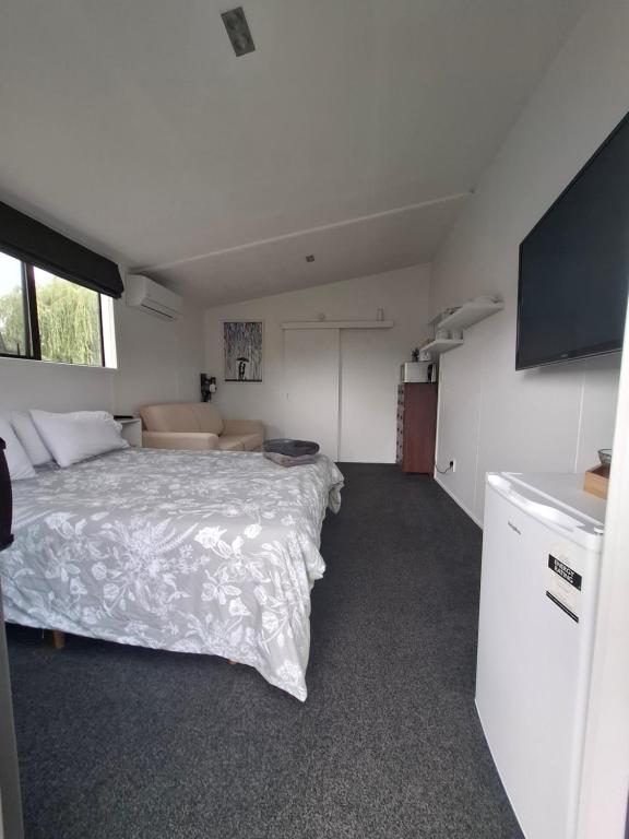 una camera con un letto e un divano di Shambala a Te Kauwhata