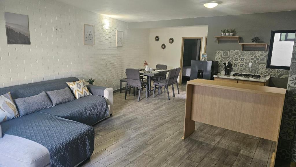 a living room with a blue couch and a kitchen at Suite Perote in Perote