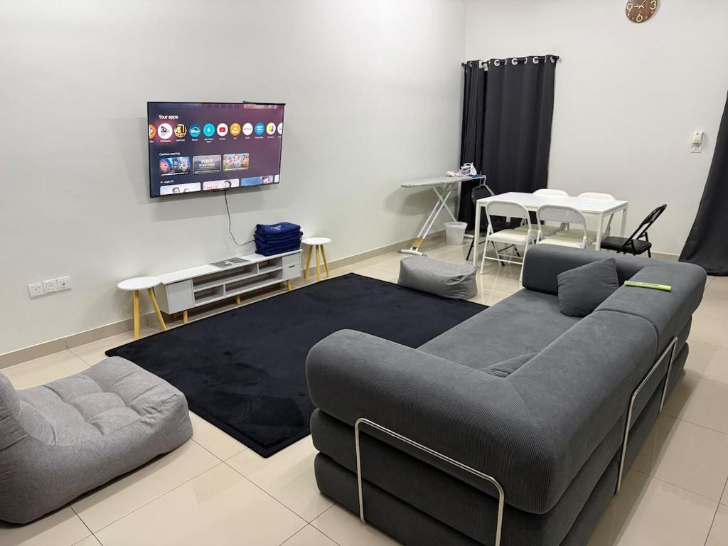 Una sala de estar con un sofá y un televisor de pantalla plana. en QQ UniStay, en Pagoh