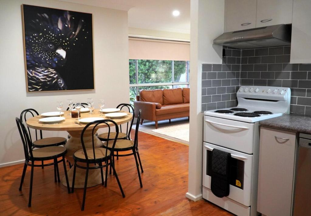 Denman Stay - Worker Friendly & Great Value في Denman: مطبخ وغرفة طعام مع طاولة وموقد