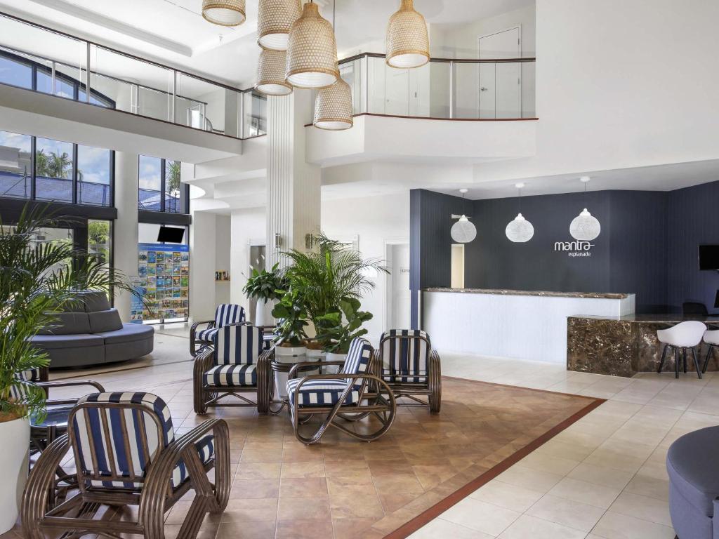 a lobby with chairs and a bar in a building at Mantra Esplanade in Cairns