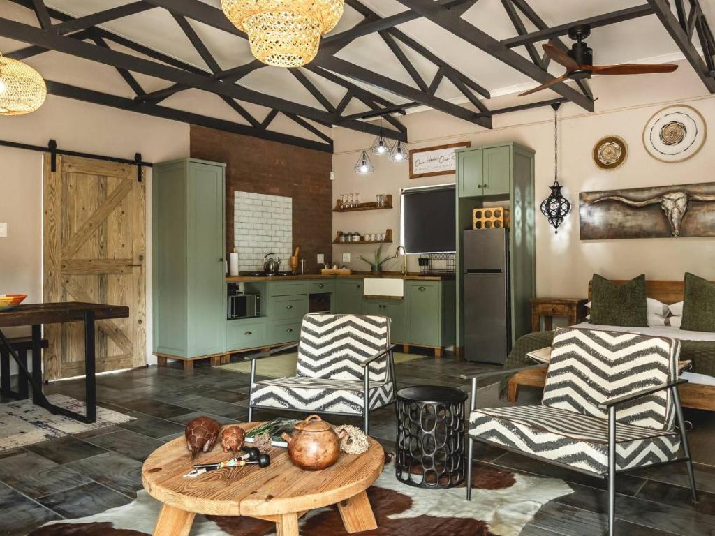 a living room with a table and chairs and a kitchen at Grace of Africa, Couples 5 STAR Nature Lodge in Marloth Park