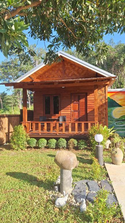 a small log cabin with a porch in a yard at Stay at Lanta Bungalow in Ko Lanta