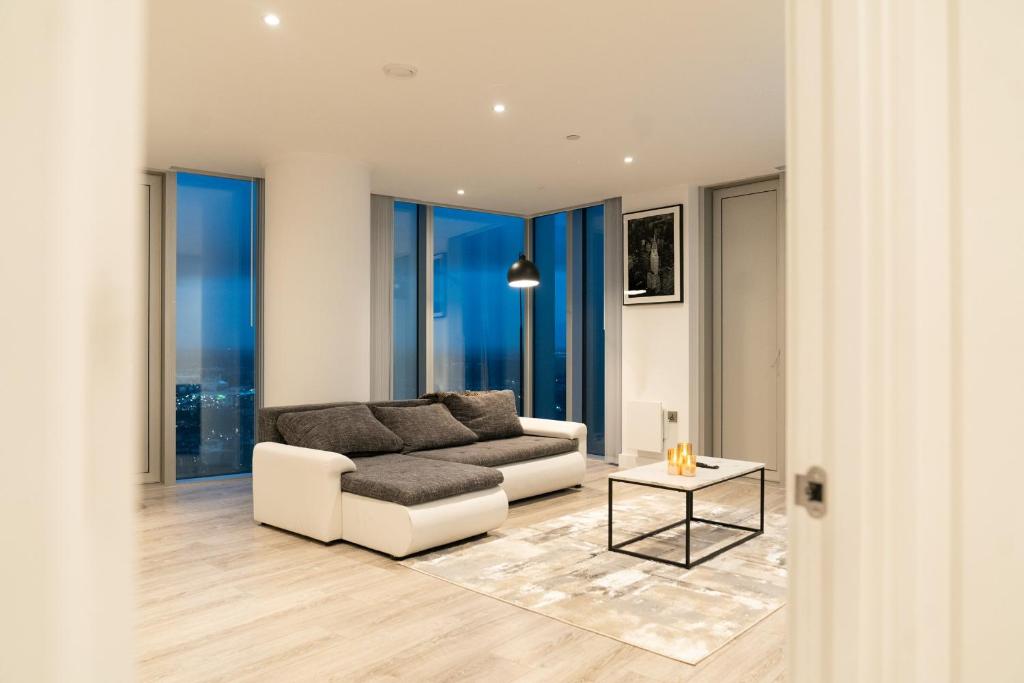 ein Wohnzimmer mit Sofa und Tisch in der Unterkunft Luxury 2 Bed Penthouse with Stunning Views in Manchester City Centre in Manchester