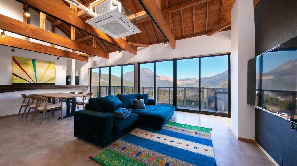 un salon avec un canapé bleu et une table dans l'établissement Yufuin Tsubaki, à Yufu