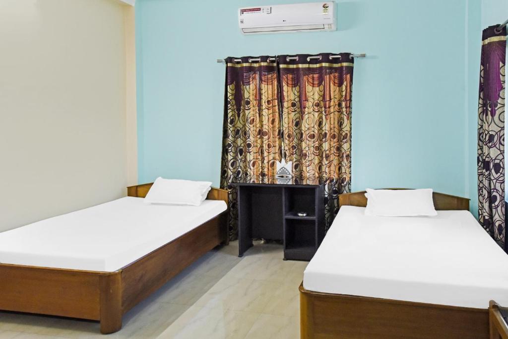 Zimmer mit 2 Betten und einem Kamin in der Unterkunft Hotel O Rainbow in Tezpur