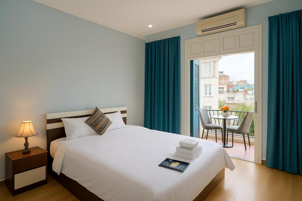 a bedroom with a bed and a balcony with a table at Eco Hotel in Hanoi