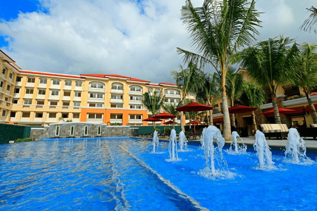a pool with water fountain in front of a hotel at San Remo Oasis at City Di Mare in Cebu City