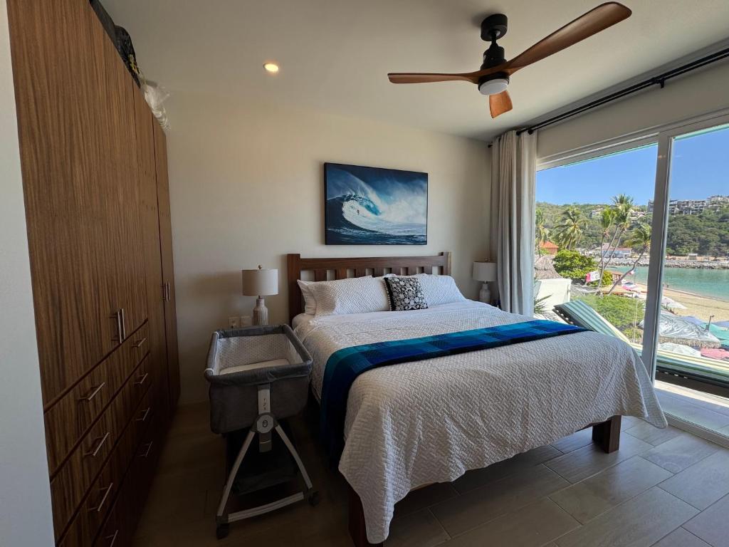 Playa Sur Paradise - Beachfront Living في سانتا كروز هواتولكو: غرفة نوم بها سرير ونافذة كبيرة