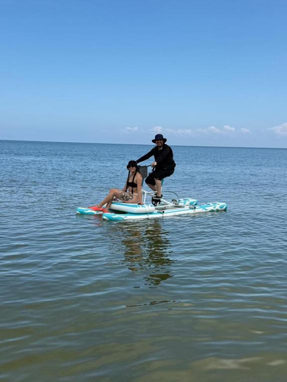 a man and a woman on a paddle board in the water at Monkey Afro Hostel in San Antero