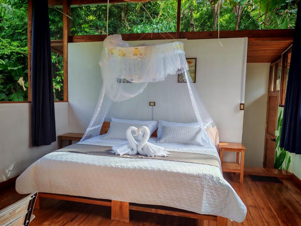 een slaapkamer met een bed met twee zwanen erop bij mirador pico de hoz lodge in Pillcopata