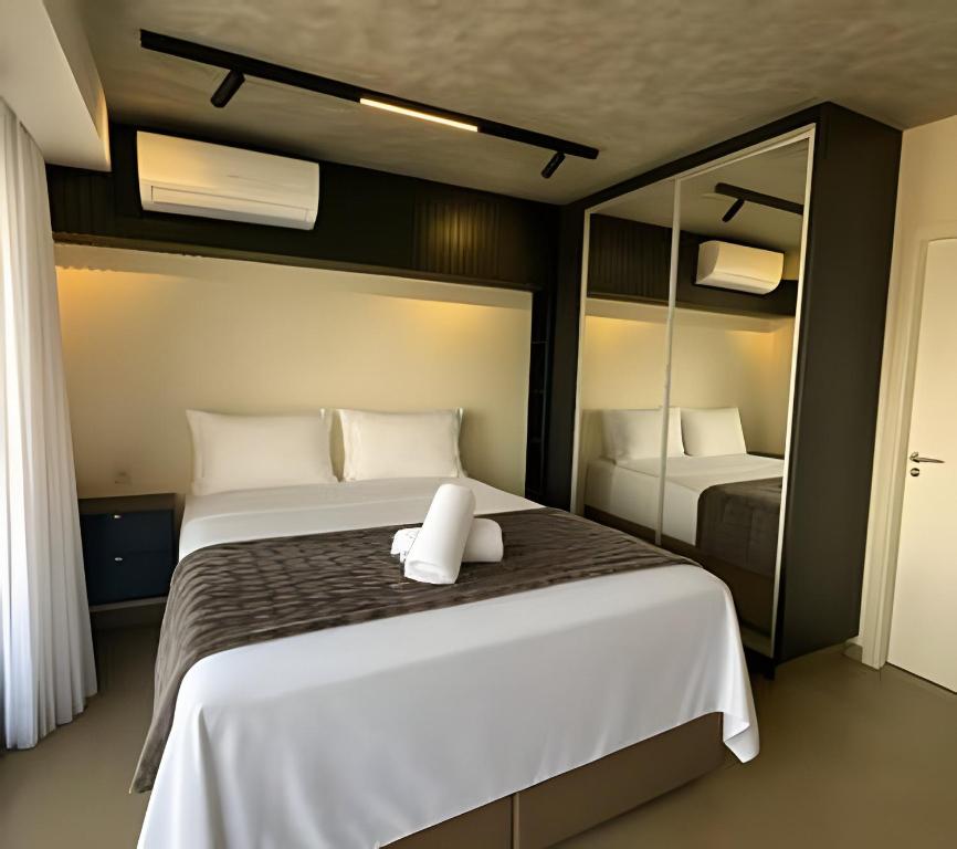 une chambre avec deux lits et un grand miroir dans l'établissement Flat Luxo 35º Andar • Vista Incrível da Cidade, à Goiânia