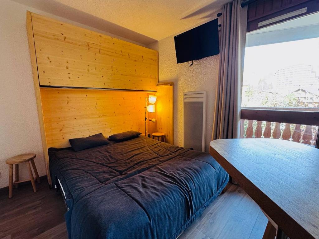 a bedroom with a bed and a large window at Studette cosy pour 2 aux Deux Alpes avec balcon - FR-1-546-62 in Les Deux Alpes