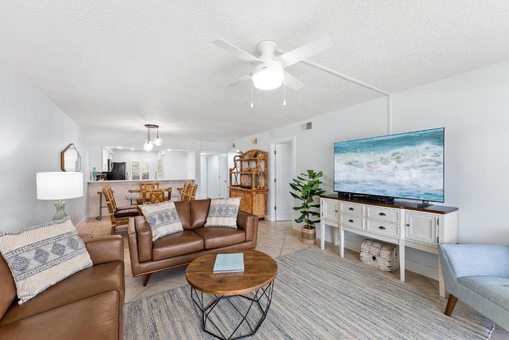 a living room with a couch and a tv at Sandcastles 103 in Cocoa Beach
