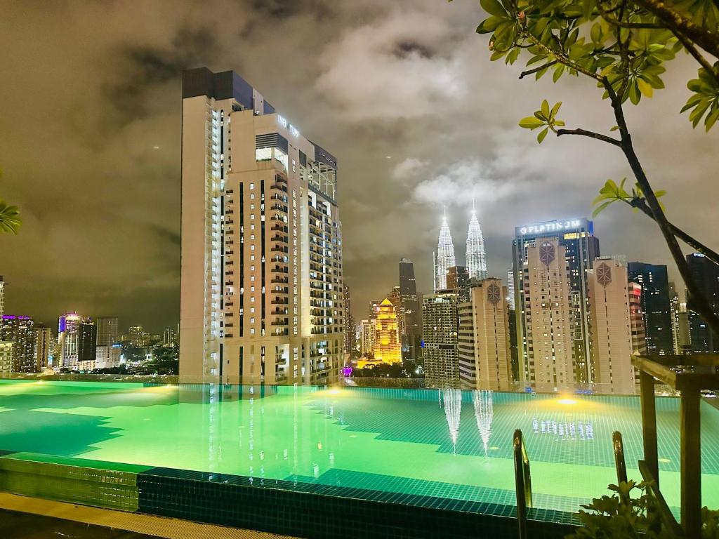 una grande piscina con vista sulla città di notte di Majestic Residence KLCC By Alfa a Kuala Lumpur