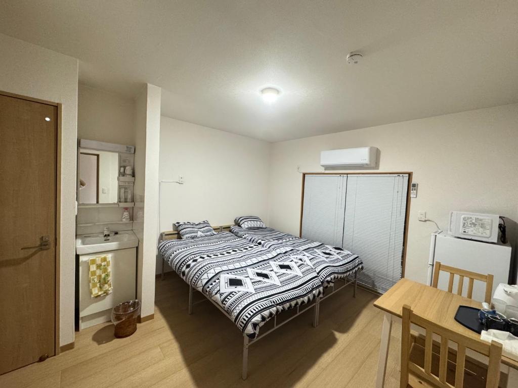 ein Schlafzimmer mit einem Bett und einem Tisch darin in der Unterkunft Ippaku 一泊 in Izumi-Sano