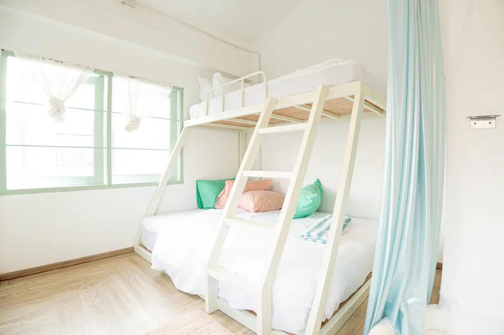 a bedroom with a bunk bed with a ladder at The Green Khaosan Bangkok in Bangkok