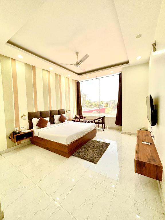 a bedroom with a bed and a television in it at Hotel Green Plaza Murthal Sonipat in Sonīpat